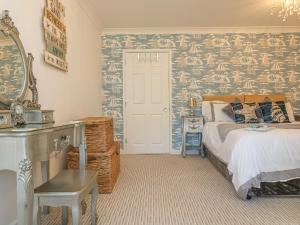 ChacewaterにあるDemelza Cottageのベッドルーム1室(ベッド1台付)が備わります。壁に壁画が飾られています。