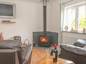 a living room with a wood stove in a living room at Demelza Cottage in Chacewater