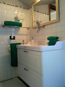 La mansarda di Mi&Lo junior suite في بولاّتي: حمام مع حوض ومرآة ومناشف خضراء