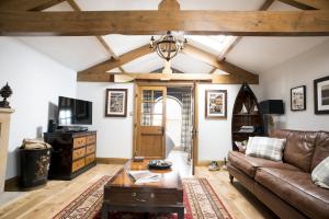 uma sala de estar com um sofá e uma mesa em Duke of Portland Boathouse on the shore of Lake Ullswater ideal for a romantic break em Pooley Bridge