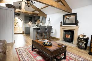 a living room with a table and a fireplace at Duke of Portland Boathouse on the shore of Lake Ullswater ideal for a romantic break in Pooley Bridge