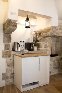 cocina con pared de piedra y encimera blanca en Villa Four Winds IV, en Dubrovnik