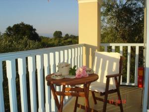 una mesa de madera y una silla en el balcón en Aroggia Farm, en Xanthátai
