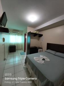 Habitación de hotel con cama y TV en Araguaia Hotel en Bom Jesus