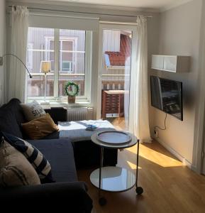 a living room with a couch and a table at Fin lägenhet med balkong - Centralt o bra läge in Käringön