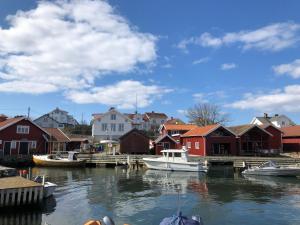 a group of boats docked in a harbor with houses at Fin lägenhet med balkong centralt o bra läge in Käringön