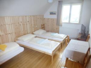 een kamer met drie bedden en een raam bij Villa Ester in Tatranská Lomnica +9 foto's