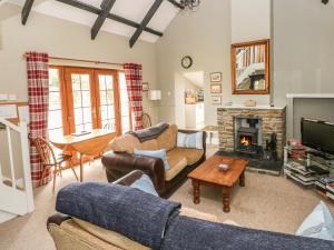 uma sala de estar com dois sofás e uma lareira em Foxglove Cottage em Haverfordwest