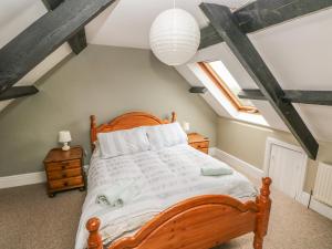 a bedroom with a wooden bed in a attic at Foxglove Cottage in Haverfordwest