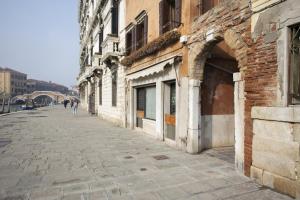 eine Person, die eine Straße entlang geht, neben einem Gebäude in der Unterkunft Ca D Oro Cannareggio in Venedig