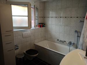 y baño con bañera, aseo y lavamanos. en B&B Im Bitzi, en Zuzwil