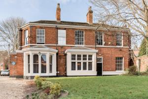 an old brick house with a white front porch at The Leeming at Claremont Apartments in Leeds