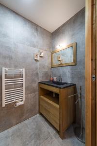 een badkamer met een wastafel en een spiegel bij ODYSSEE CRC04 - Charmant appartement sur les pistes in La Toussuire +8 foto's