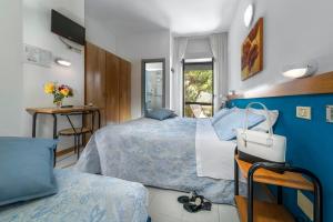 a bedroom with two beds and a blue wall at Hotel Morotti in Misano Adriatico