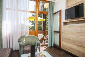 a living room with a couch and a television at AktiVital Hotel in Bad Griesbach