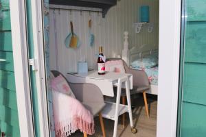 a table with two chairs and a bottle of wine at Hopgarden Glamping and camping - Luxury furnished Bell tents & Shepherd huts plus camp field to pitch your own tents in Wadhurst