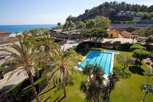 an aerial view of a resort with a pool and palm trees at The Hollidays Apartment in Calella