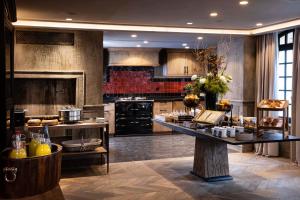 a large kitchen with a table with food on it at H&ocirc;tel Saint-Delis - La Maison du Peintre - Relais & Ch&acirc;teaux in Honfleur