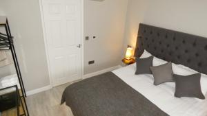 um quarto com uma cama grande e uma grande cabeceira. em Flat 2 Castle Street Serviced Apartments em Telford