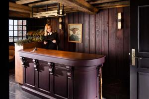 a woman standing behind a bar in a room at Hôtel Saint-Delis - La Maison du Peintre - Relais & Châteaux in Honfleur