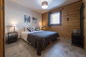 een slaapkamer met een bed en een raam bij ODYSSEE CRC04 - Charmant appartement sur les pistes in La Toussuire