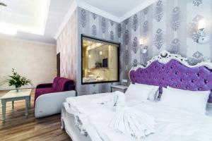 a bedroom with a white bed and a purple headboard at Pałac Margot Nature&SPA in Karpacz