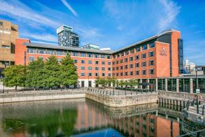 a large brick building next to a body of water at Crowne Plaza Liverpool City Centre by IHG in Liverpool