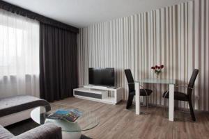 a living room with a table and a television at Hotel Asahi in Düsseldorf
