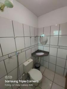 a bathroom with a white toilet and a sink at Araguaia Hotel in Bom Jesus
