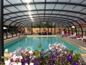 a swimming pool with a glass ceiling and people at CAMPING DES OISEAUX- Baie de Somme in Rue