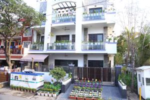 Biały budynek z kupą roślin przed nim w obiekcie joerose villa w mieście Noida