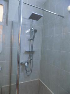 a shower with a shower head in a bathroom at Pension Eden in Băile Herculane