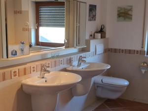 een badkamer met 2 wastafels, een toilet en een raam bij Wohnen im orientalischen Ambiente in Harthausen