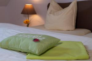 a green pillow sitting on top of a bed at Ein Bett im Norden in Fehmarn
