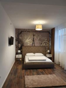 a bedroom with a large bed and a wall with a tower at ARISTOCRAT CENTRAL in Târgu Jiu