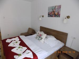 een slaapkamer met een bed met witte lakens en een rode deken bij Pension Eden in Băile Herculane