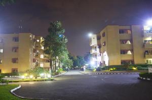 una strada vuota di notte davanti agli edifici di Peniel Apartments ad Abuja