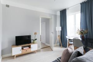 a living room with a tv on a wooden stand at Linne Apartment in Uppsala