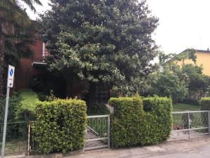 una cerca frente a una casa con un árbol en HOUSE&GARDEN en San Donato Milanese