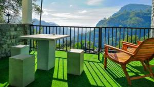 Paraiso Guest House في إيلا: طاولة وكرسي على شرفة مطلة
