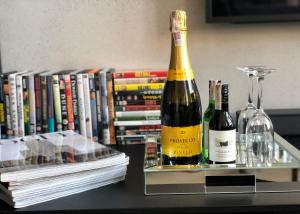 dwie butelki wina na stole obok książek w obiekcie Neon Loft Apartament Bukowskiego w mieście Białystok