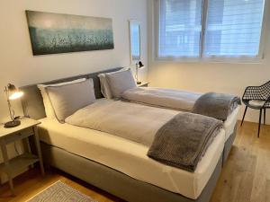 a bedroom with two beds and a table with a lamp at Apartment SnowKaya by Interhome in Engelberg