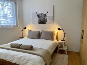 a bedroom with a bed with a bull picture on the wall at Apartment SnowKaya by Interhome in Engelberg