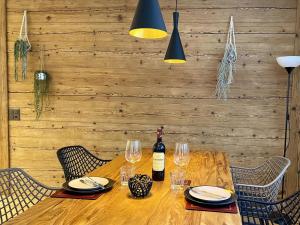 a wooden table with a bottle of wine and glasses at Apartment SnowKaya by Interhome in Engelberg