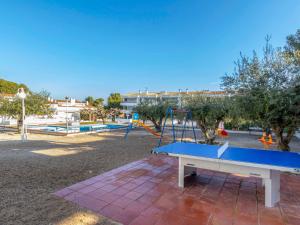 a ping pong table and swings in a park at Apartment Ursula by Interhome in Torredembarra