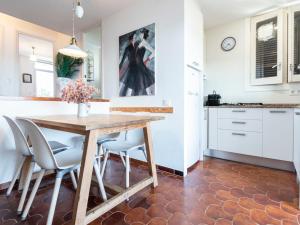 cocina y comedor con mesa de madera y sillas en Apartment Ursula by Interhome, en Torredembarra