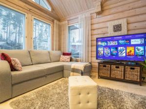 Il comprend un salon doté d'un canapé et d'une télévision à écran plat. dans l'établissement Holiday Home Akavilla 2 by Interhome, à Jämsä