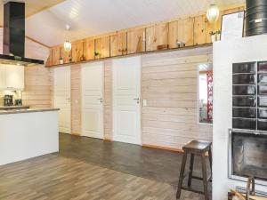 a kitchen with white doors and wooden walls at Holiday Home Aarre a by Interhome in Saariselka