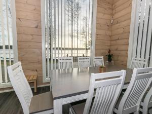 Ruovesi的住宿－Holiday Home Metsola by Interhome，一间带桌子和白色椅子的用餐室