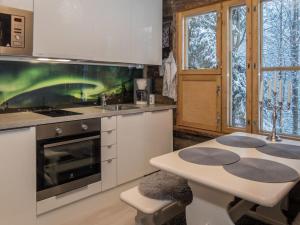 eine Küche mit einem Herd und einem Tisch darin in der Unterkunft Holiday Home Salmikangas f1 by Interhome in Ruka